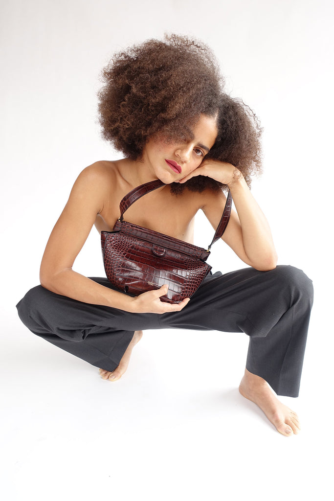 Model wearing the Phoebe bag against the body to show scale and proportions of the dumpling shaped bag.