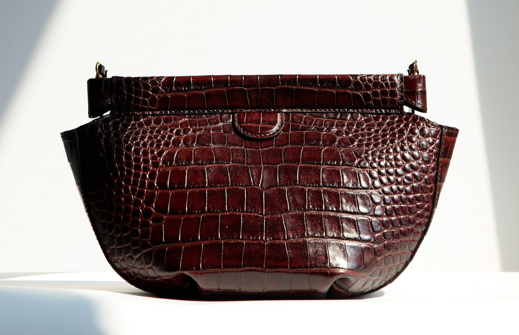 Back view of the Phoebe Dumpling Shoulder Bag, shows both pleats, side gusset and top hinged bar frame closure.  The deep brown and croc-embossed texture adds to the sophisticated style of this shoulder bag.