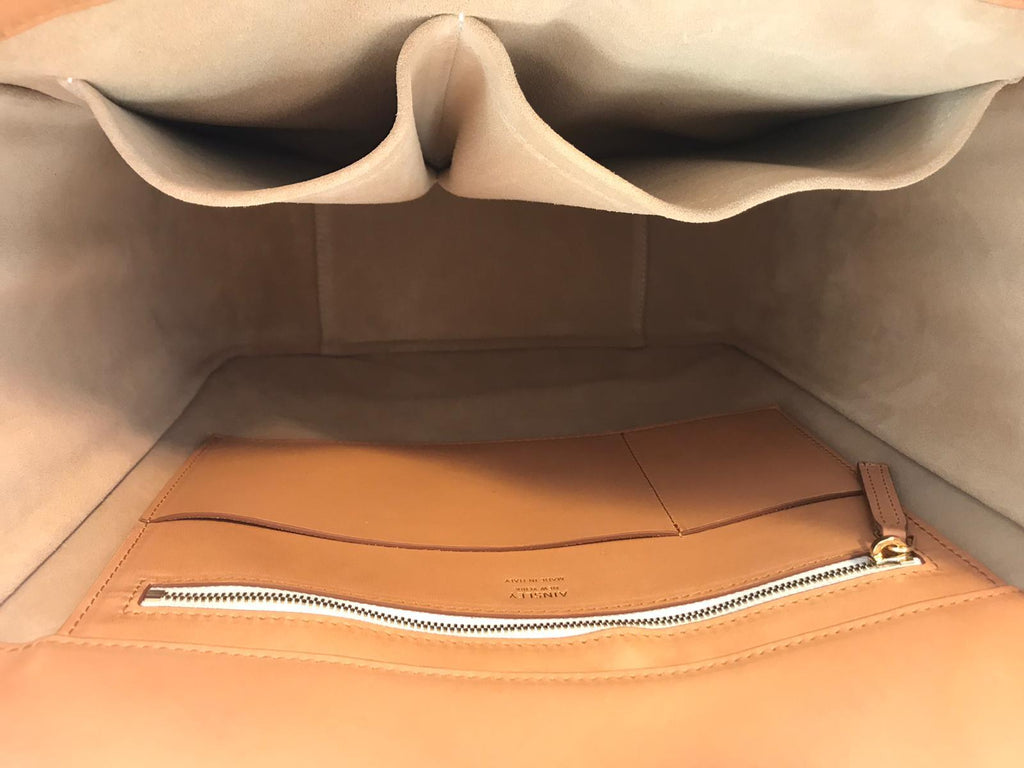 Image of the open top, interior lined in a soft suede for durability and with a zippered pocket and open pockets on both sides of the bag.