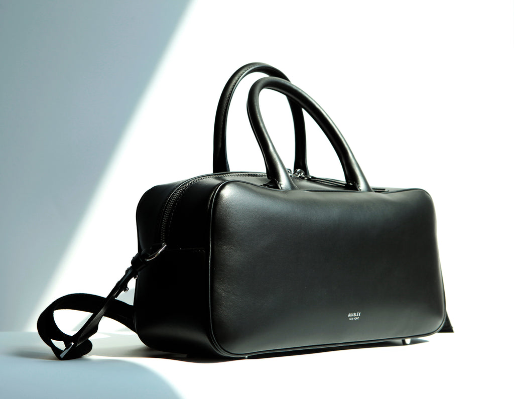 Side view of the top-handle leather satchel in smooth leather. A timeless piece with its elegant silhouette.